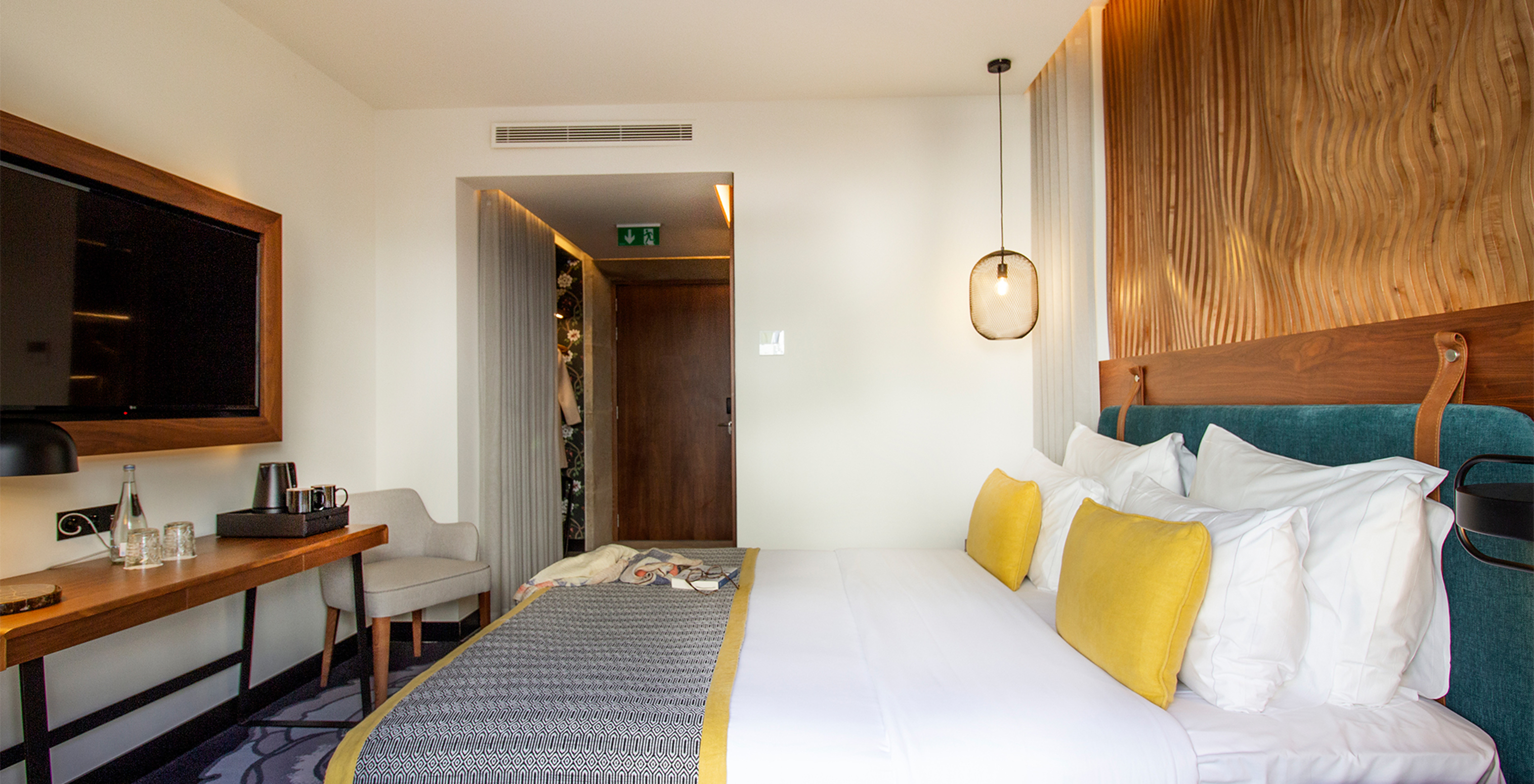 O Deluxe da Pousada Porto - Rua das Flores tem uma cama de casal e uma televisão em frente à cama