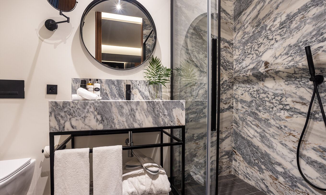 A Junior Suite da Pousada Porto - Rua das Flores tem uma casa de banho com apontamentos em preto com duche e lavatório