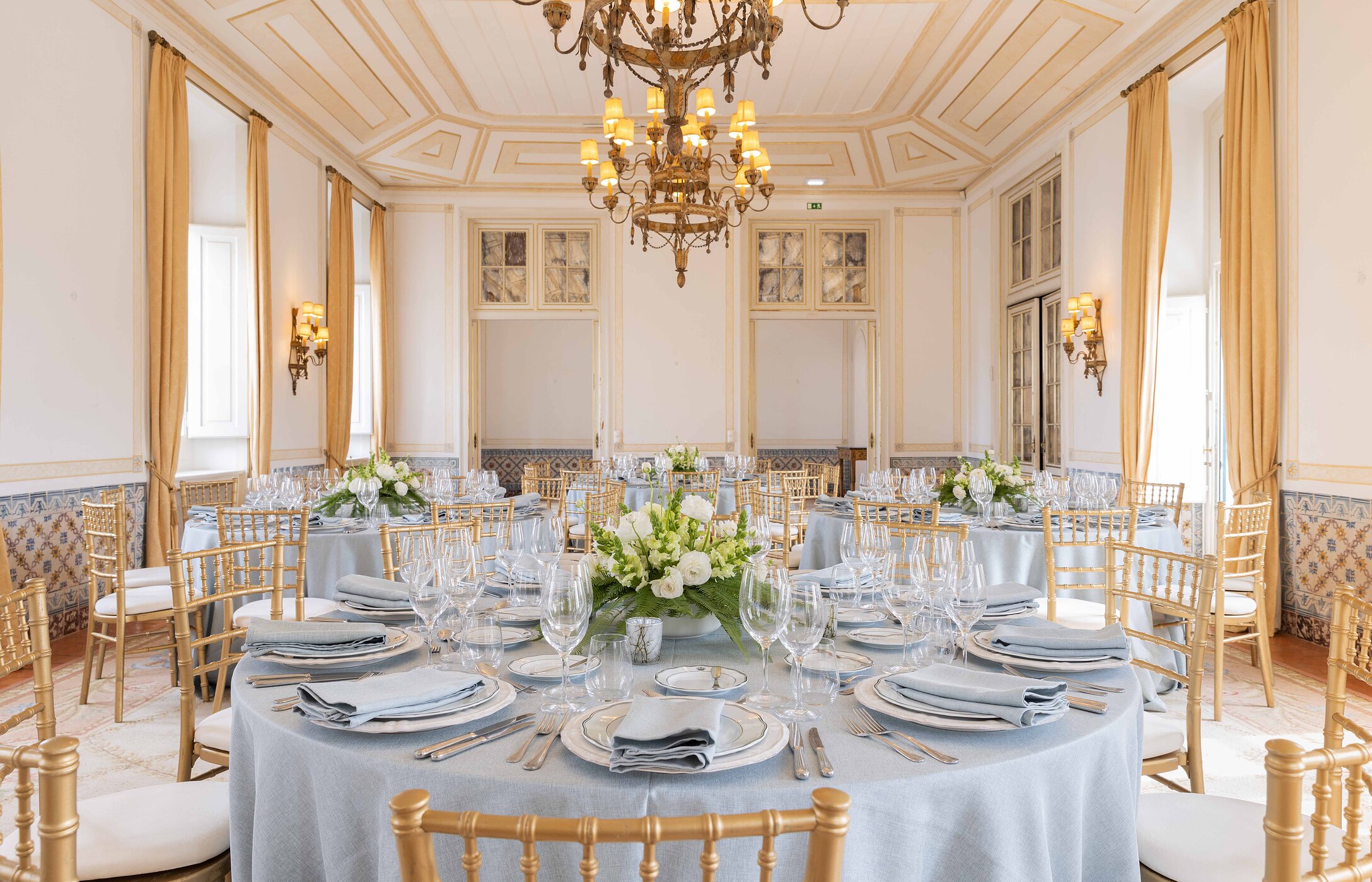 Celebre a sua ocasião especial nas Pousadas de Portugal, em sala histórica com mesas com arranjos florais e lustre dourado