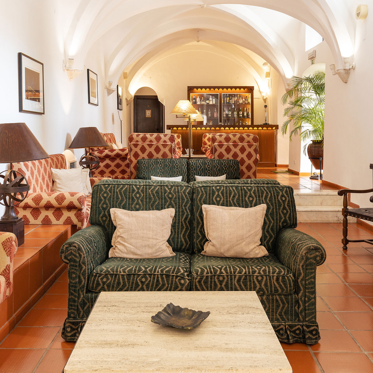 Lounge der Pousada Castelo Alvito, einem historischen Hotel mit bequemen Sofas und einer Bar im Hintergrund