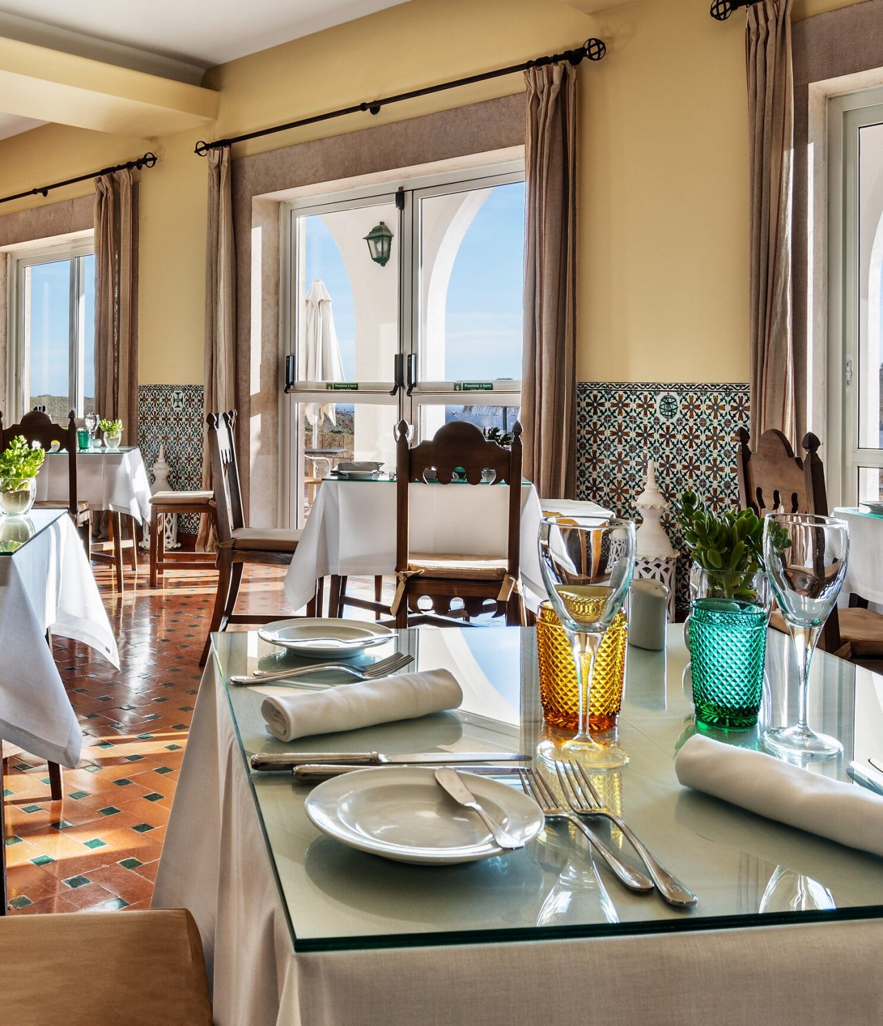Das Restaurant Pousada Sagres im historischen Hotel in Sagres hat mehrere Tische und Fenster mit Meerblick