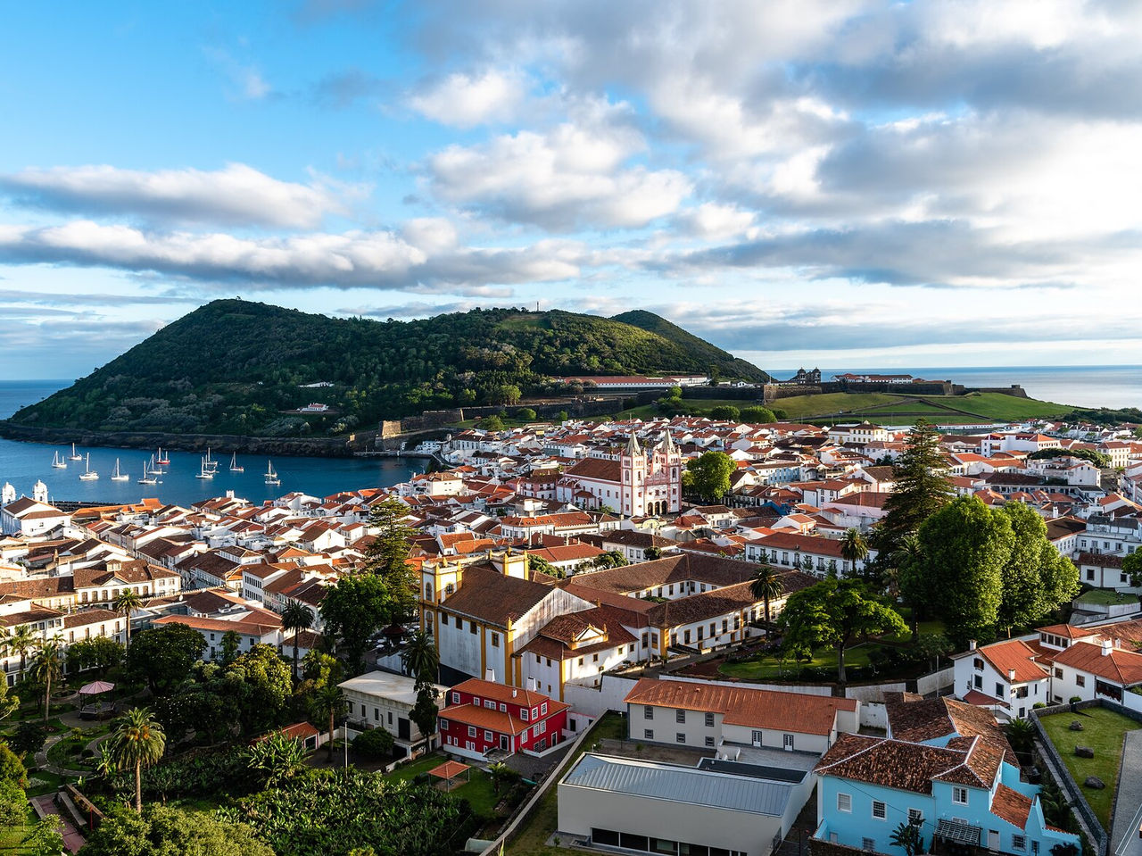 Panoramablick auf Angra do Heroísmo, auf der Insel Terceira, umgeben von grünen Hügeln und dem Atlantischen Ozean