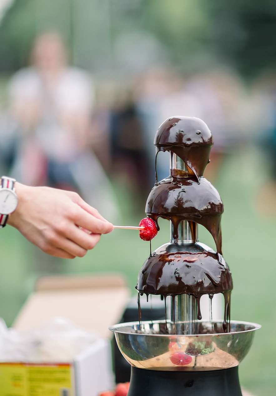 Erdbeere, die in Schokoladenfondue beim Schokoladenfestival in Óbidos getaucht wird