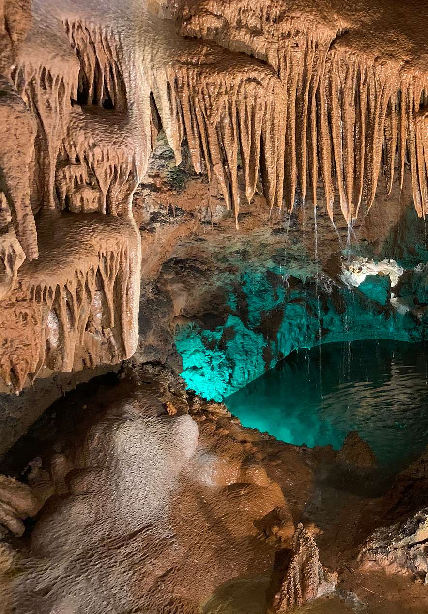Grutas de Mira de Aire mit mehreren Stalaktiten und Wasser am Grund der Höhle, nahe Ourém