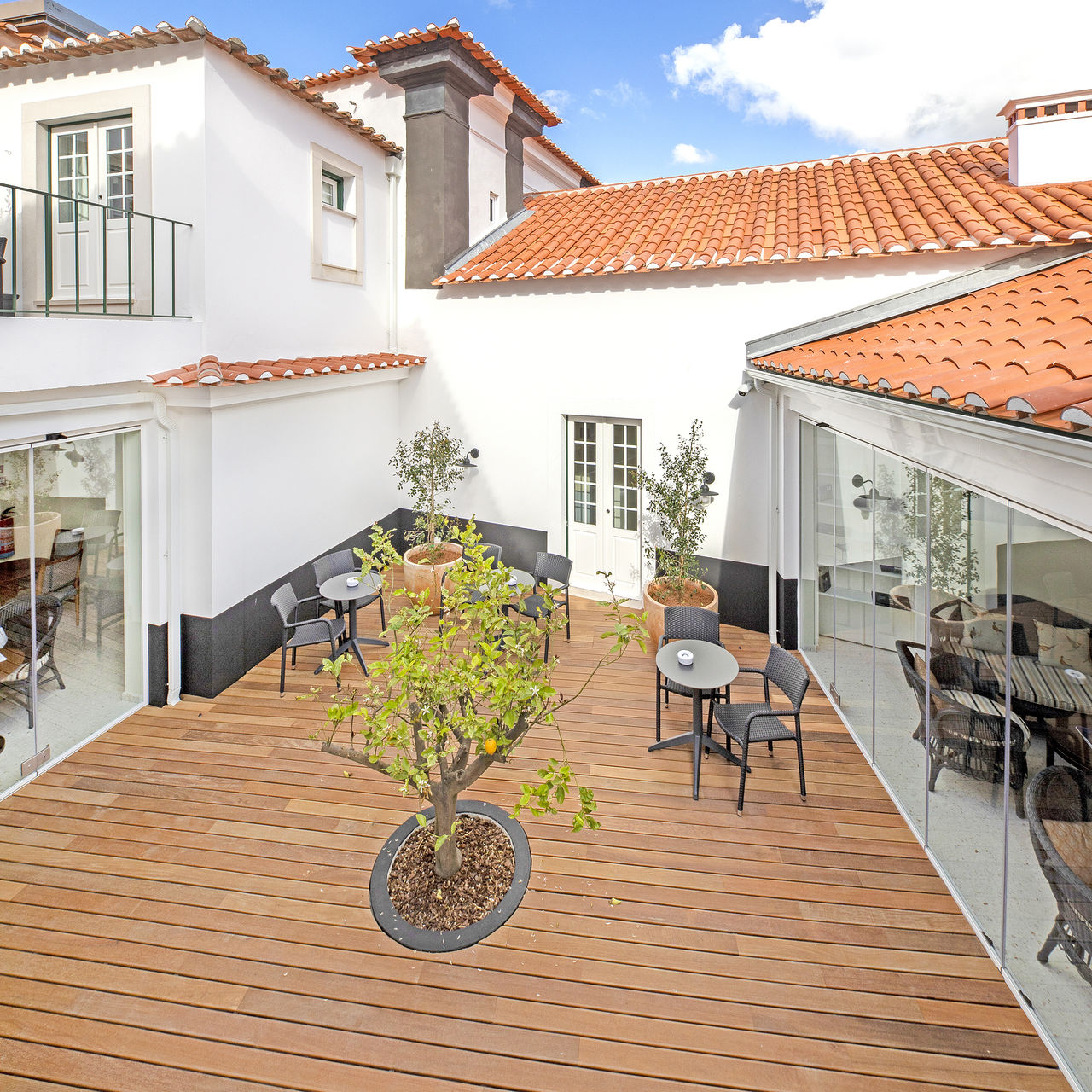 Außenpatio der Pousada Vila Óbidos, charmantes Hotel in der mittelalterlichen Stadt Óbidos mit Holzdeck und kleinem Baum