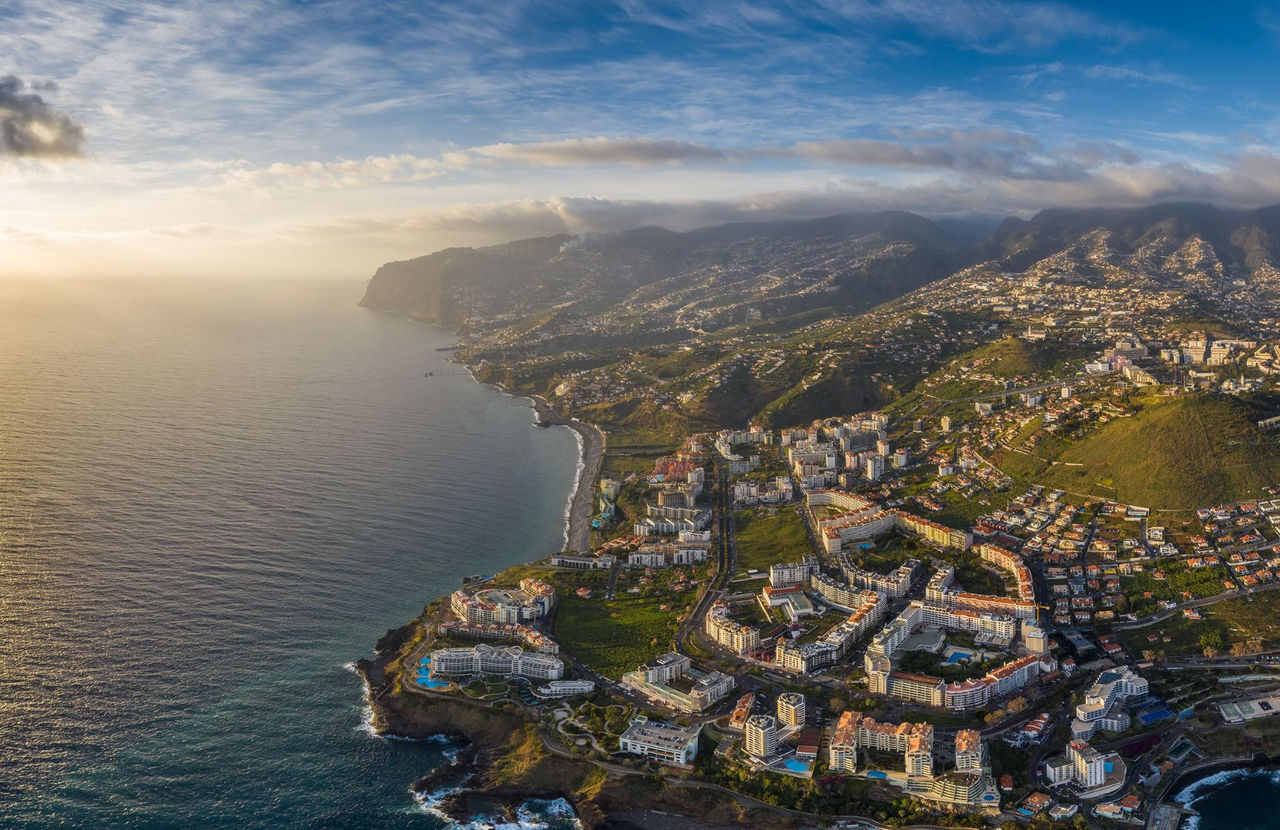 Aerial view of the city of Funchal in Madeira, with a dense urban areas, and mountains in the background