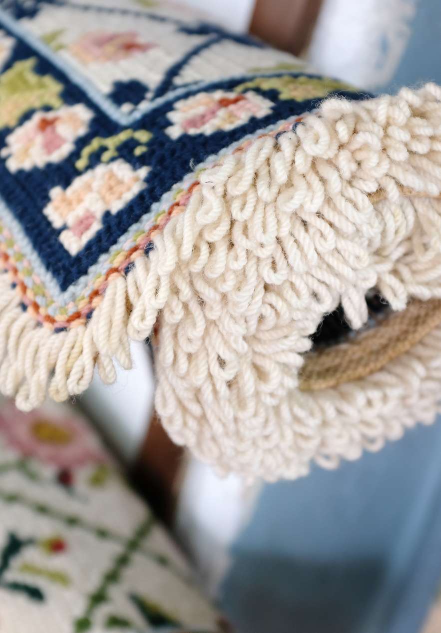 Traditional tapestry from Alentejo with a rolled rug in blue and another rug below in green