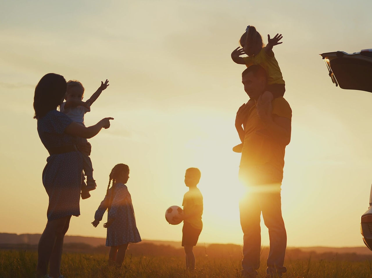 Explore Hotels in the Algarve where families play with children beside a car at sunset in open fields