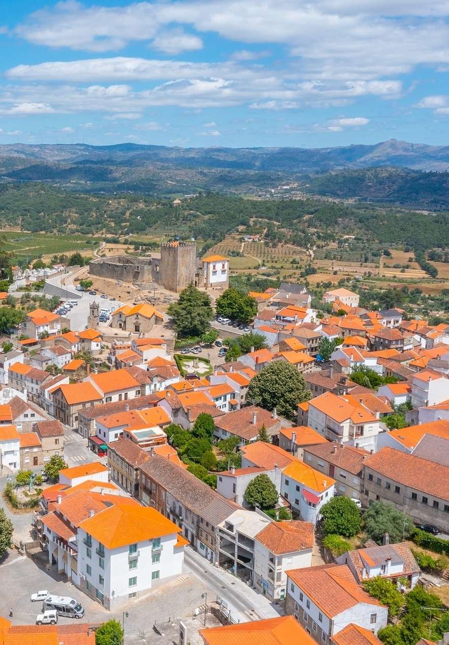 Historic village of Belmonte with several house roofs the Belmonte village castle and tree-covered mountains