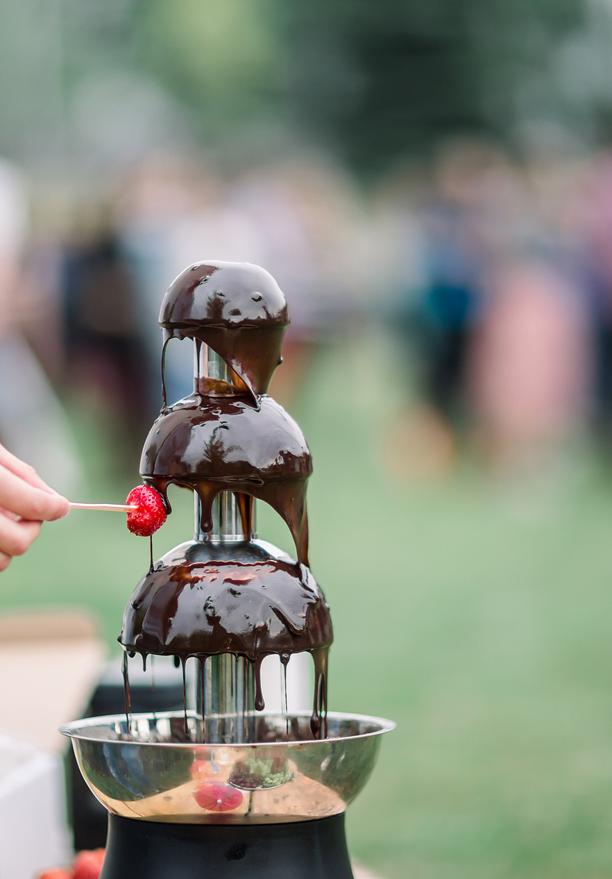Strawberry being dipped in chocolate fondue at the Óbidos Chocolate Festival