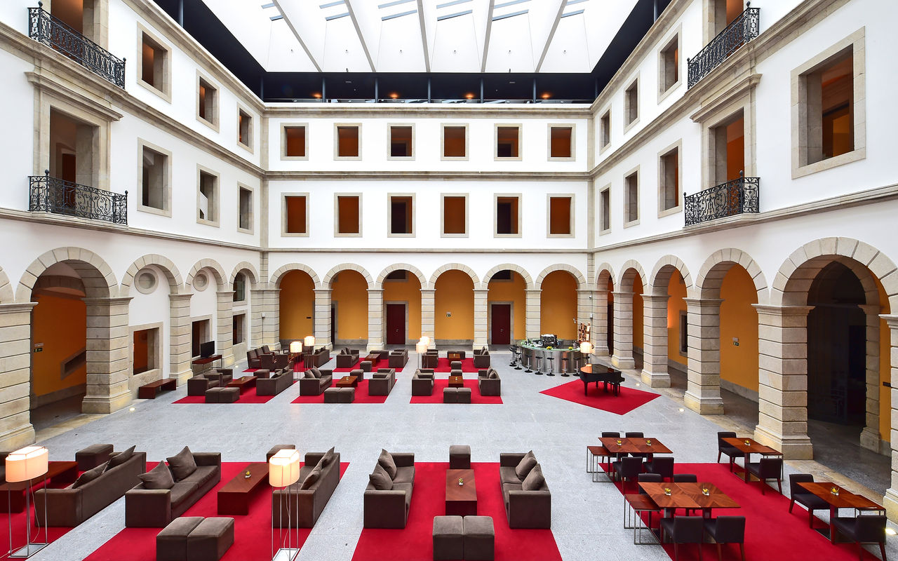 Interior courtyard of Pousada Viseu, historic hotel with arches and sofas, and a bar at the back