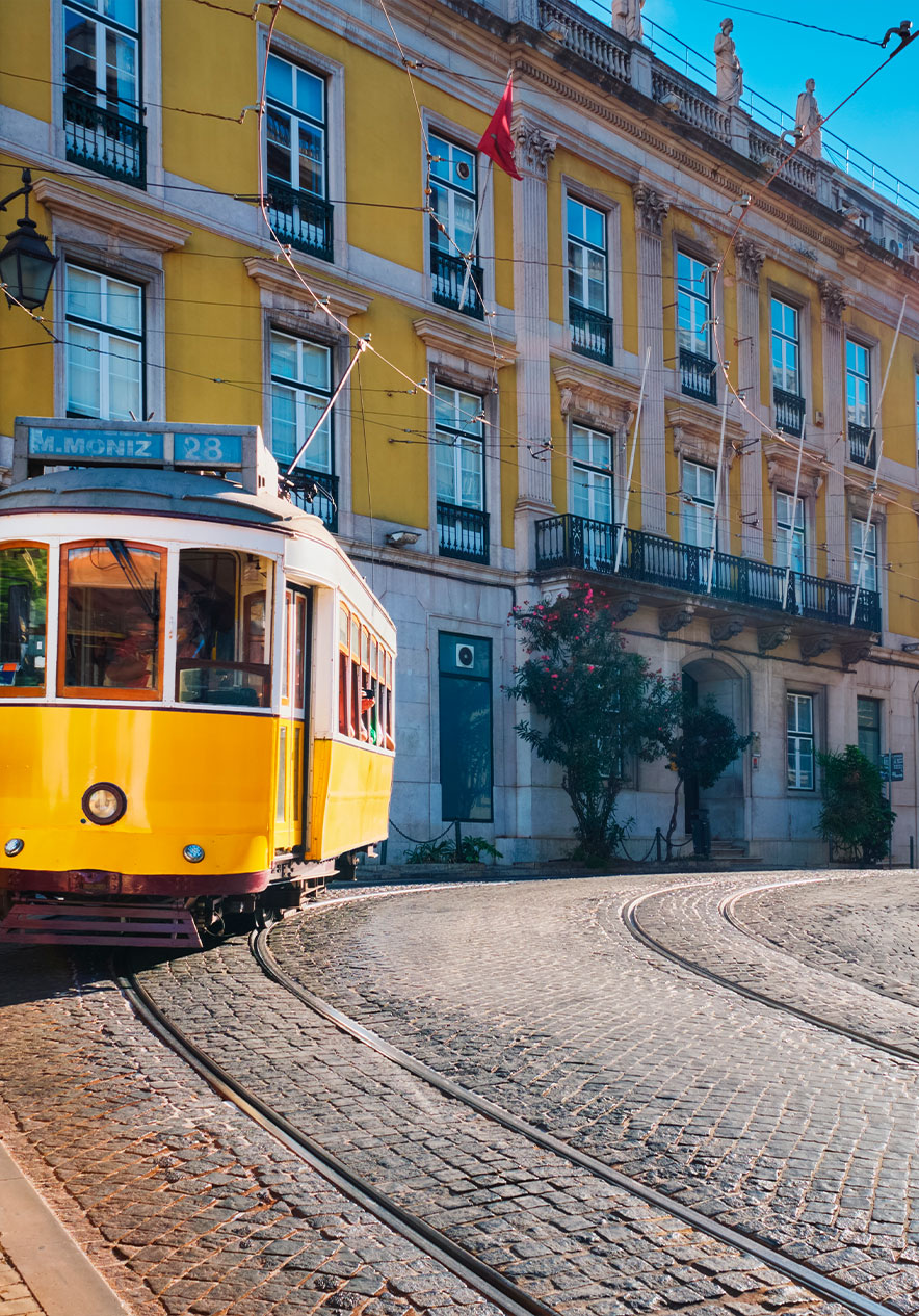 The traditional yellow tram 28 in Lisbon traveling through the historic streets in the city center