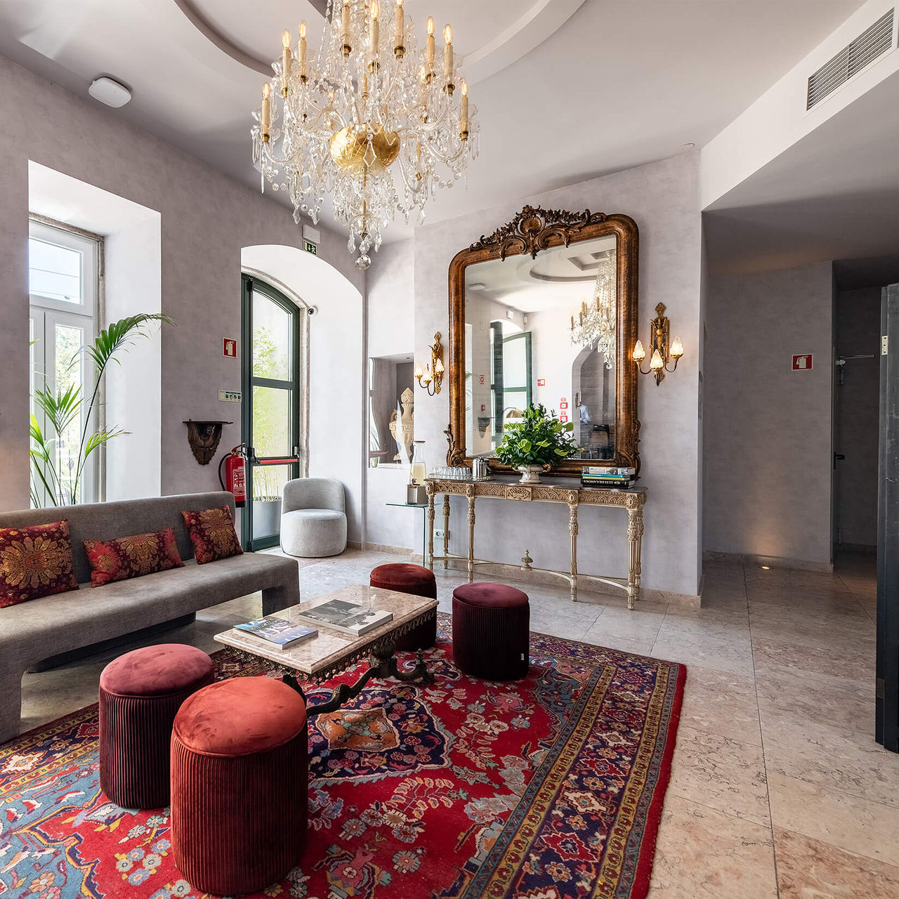 Lobby of Pousada Alfama, a hotel in the center of Lisbon, with gold, gray, and burgundy tones in its decor
