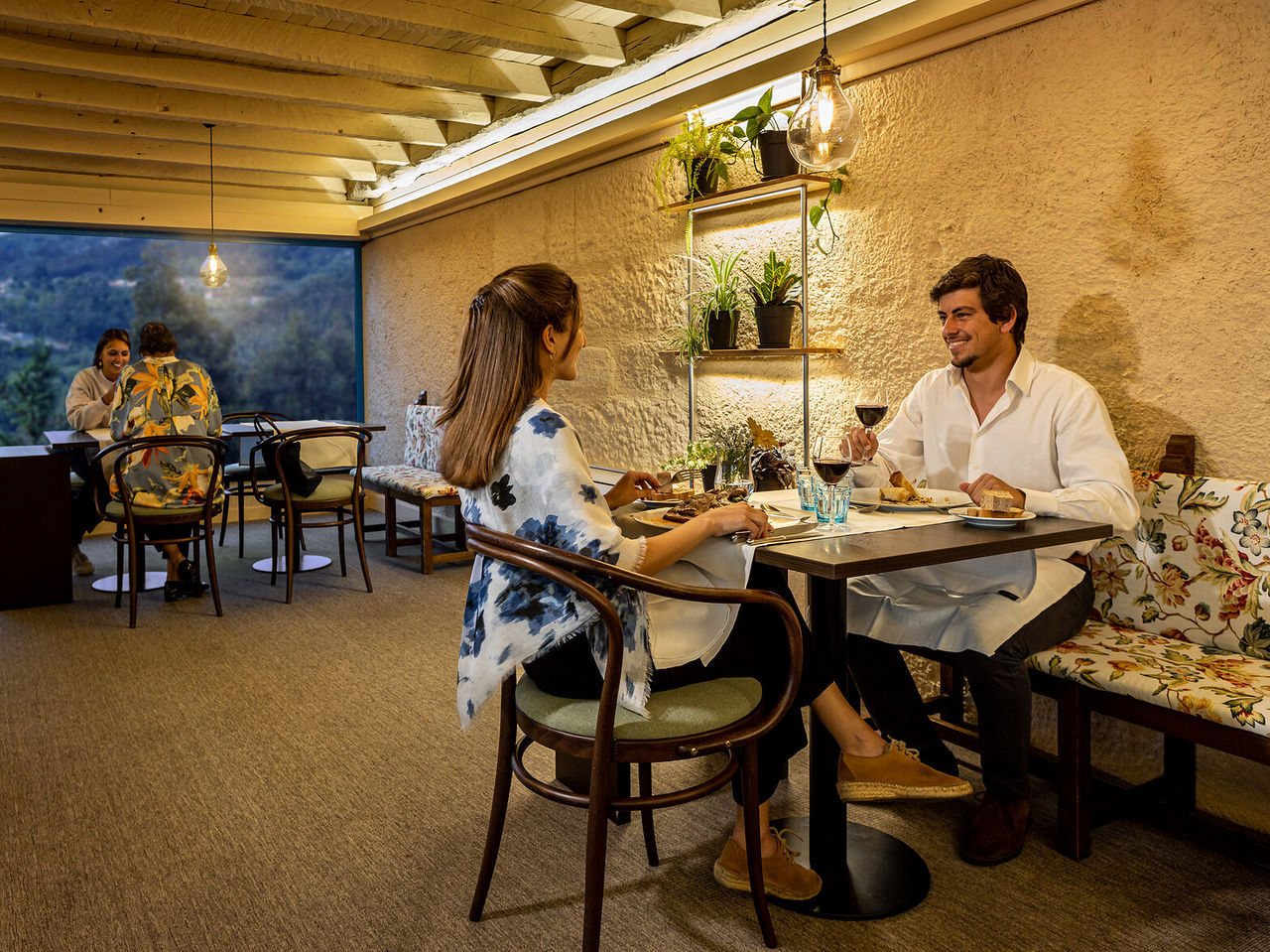 The restaurant of the Hotel in the Peneda-Gerês National Park has a well-lit interior space with tables spaced apart
