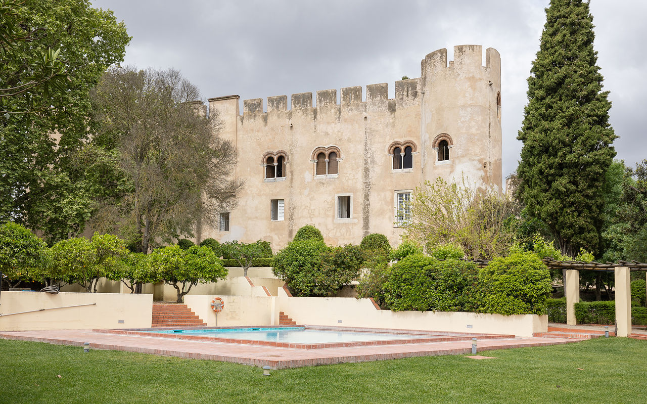 Vista exterior de Pousada Castelo Alvito, hotel histórico en Alvito, con piscina exterior y el castillo al fondo