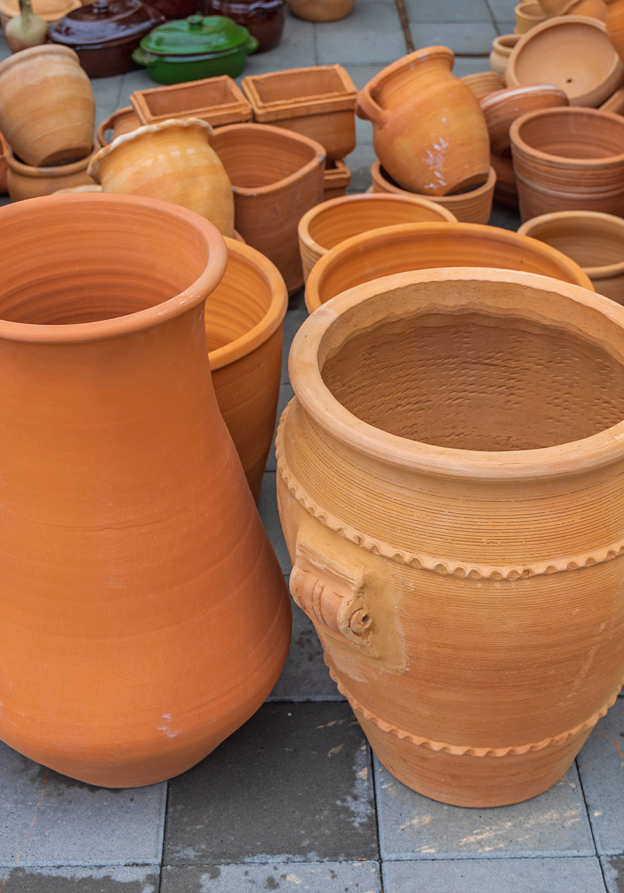 Vasos e potes de barro expostos ao ar livre na atividade Barros de Flor da Rosa perto da Pousada Mosteiro Crato