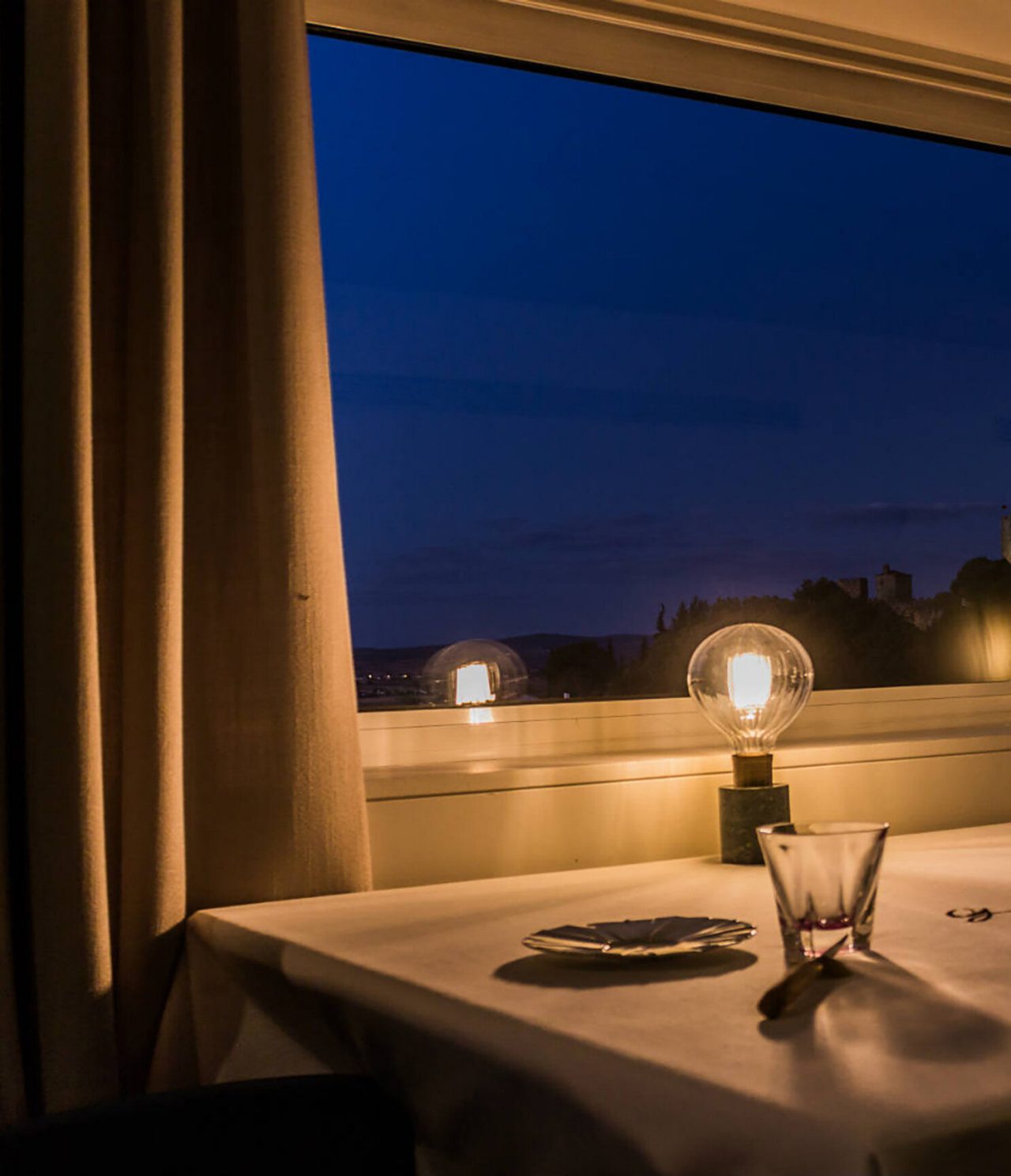 Restaurante de Pousada Bragança Hotel en el Norte, en Bragança, con mesa iluminada junto a una ventana nocturna