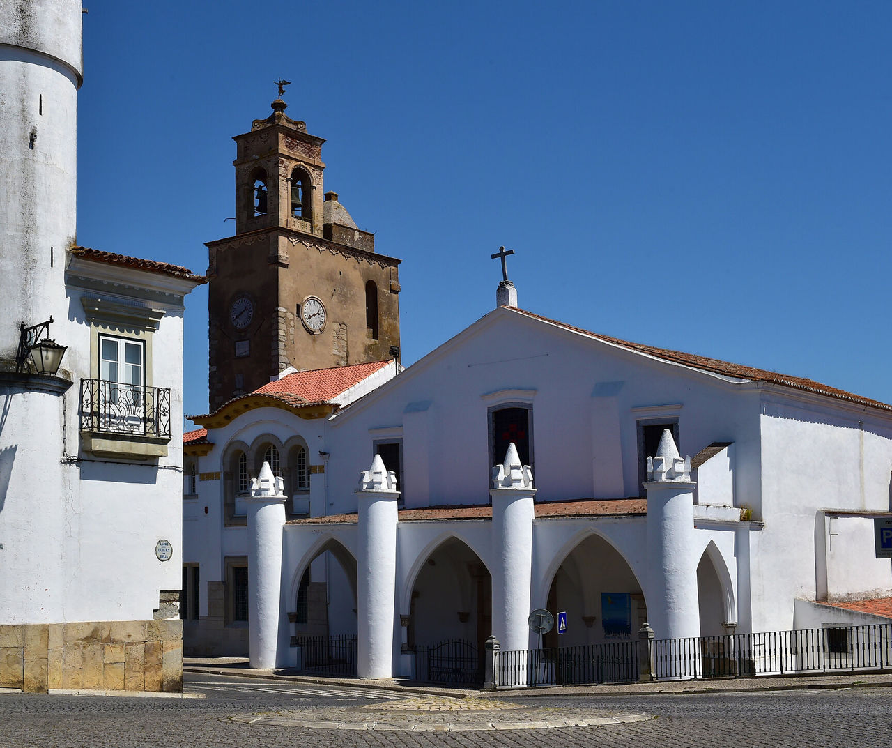 Hotel Alentejo con vistas a una iglesia blanca con campanario histórico bajo un cielo azul despejado