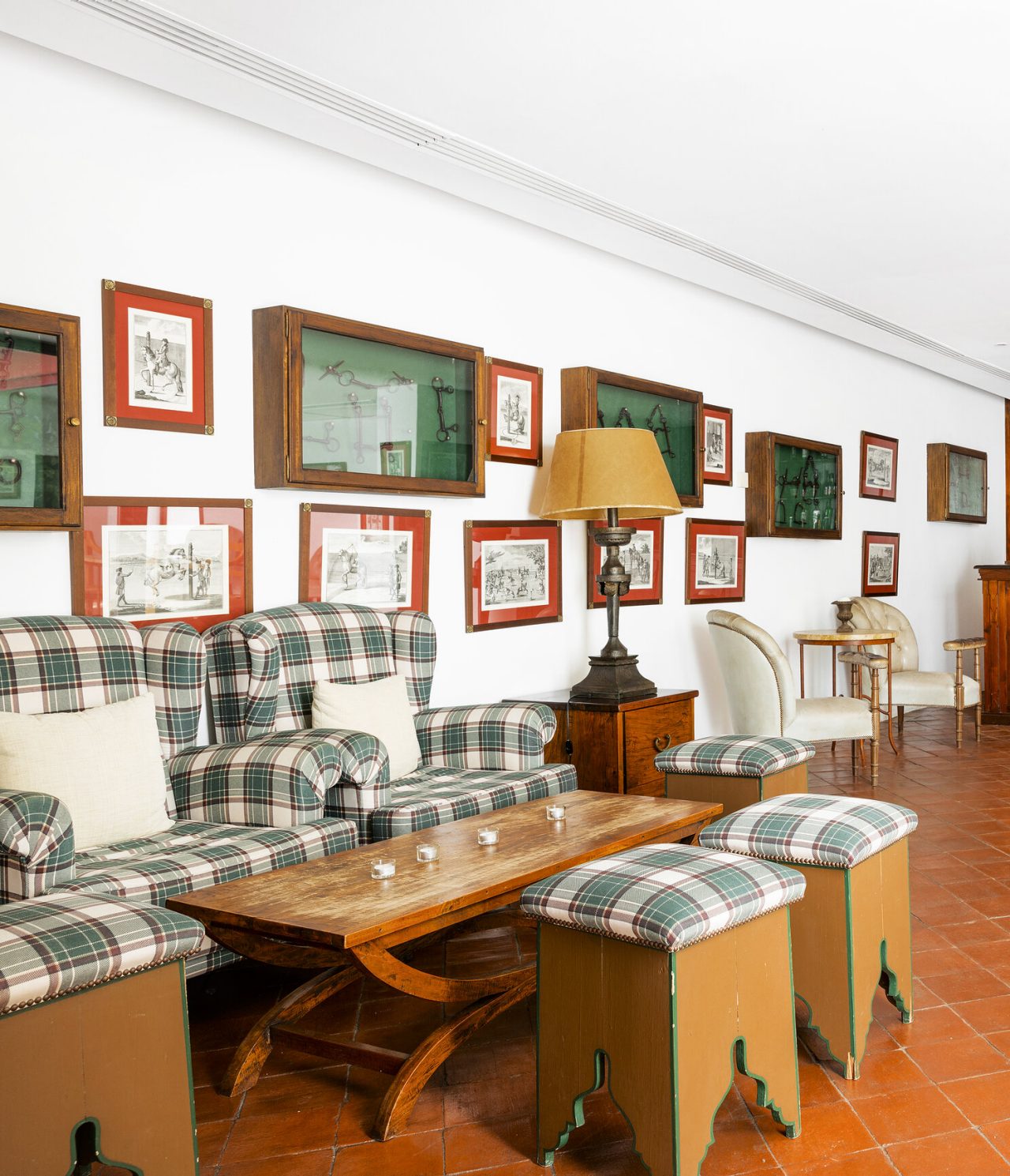 Le bar de l'Hôtel Historique à Vila Viçosa, a des fauteuils verts avec table d'appoint et tableaux au mur