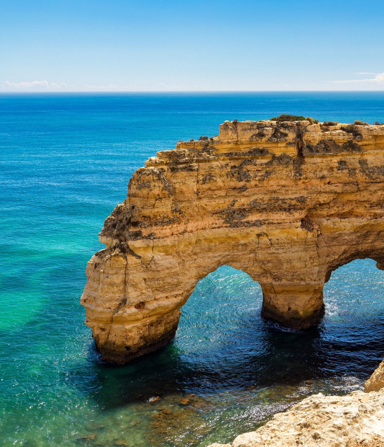Formation rocheuse naturelle en forme d'arc, avec l'océan Atlantique en arrière-plan, sur la côte de l'Algarve