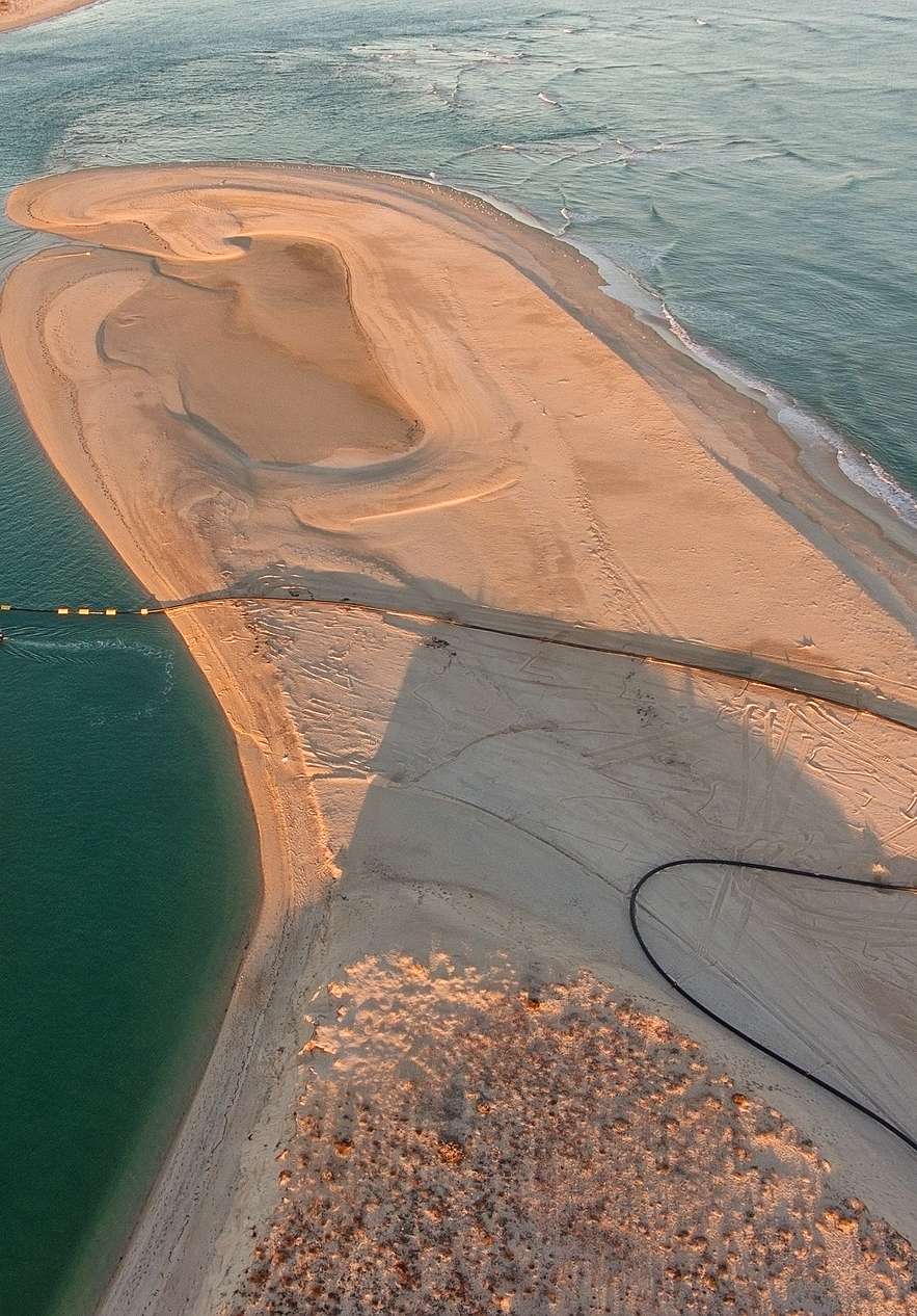 Jamanta Tour à Faro, avec un bateau naviguant sur l'eau bleue réfléchissant la couleur du ciel