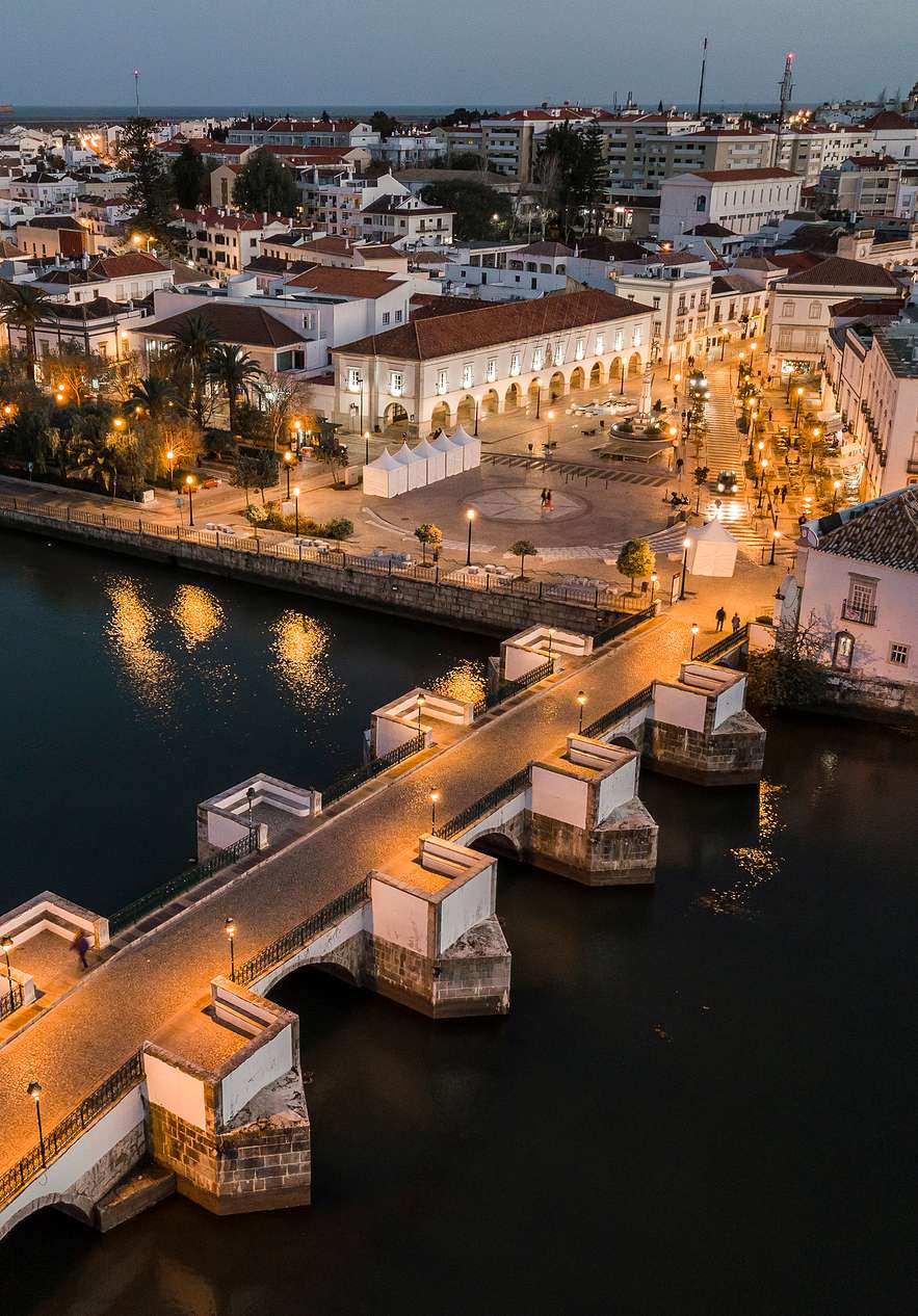 Vue typique de Tavira, avec un pont romain sur le Rio Gilão, au crépuscule, illuminant le chemin et la place