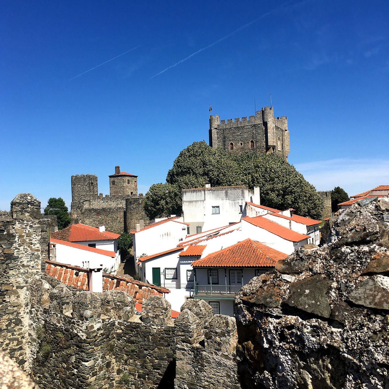 Vue sur la Pousada Bragança, avec des maisons blanches à toits rouges au centre, entourées du château