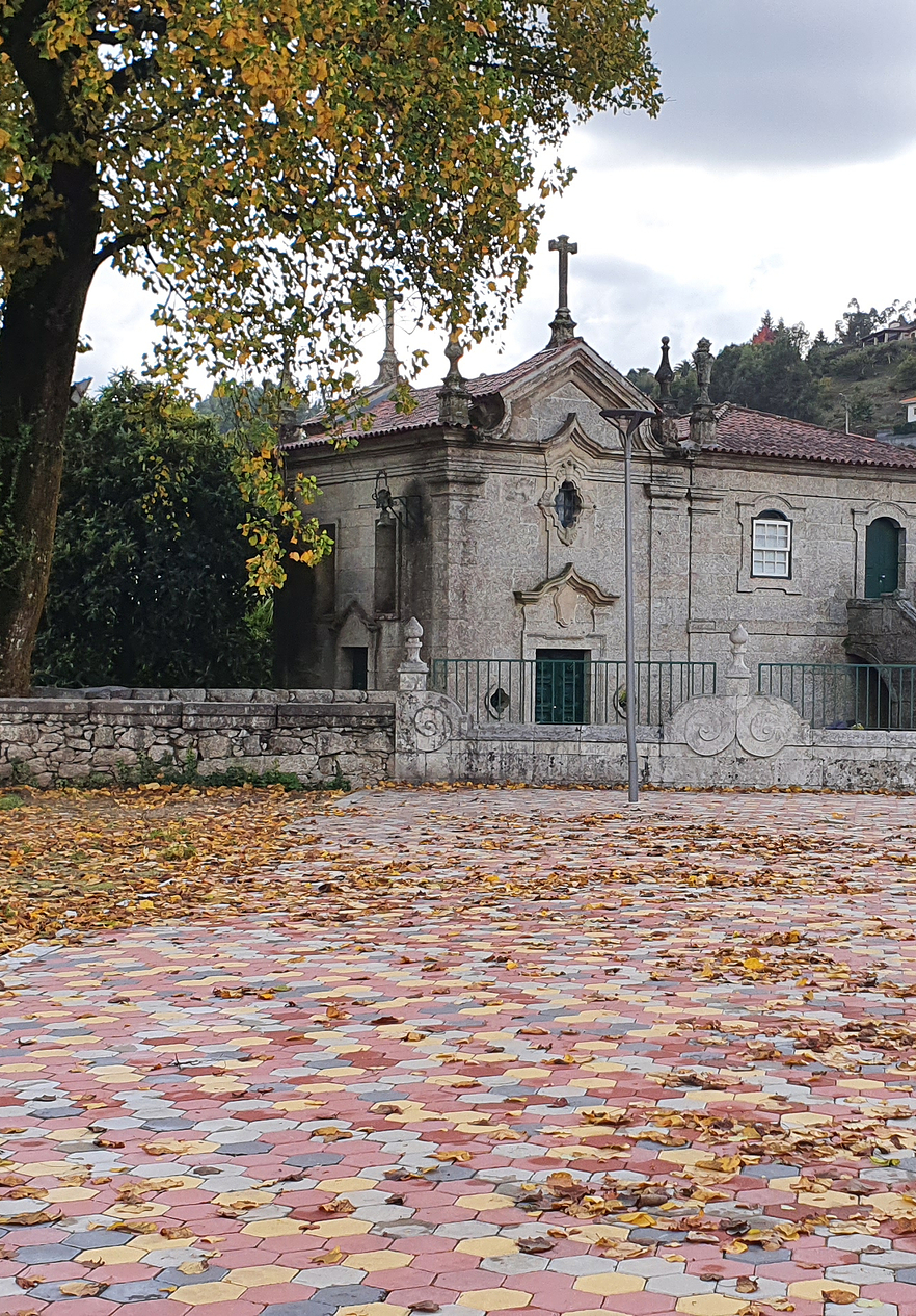Vue de la Casa Museu Adelino Ângelo, avec sa façade en pierre, des croix au sommet et des fenêtres