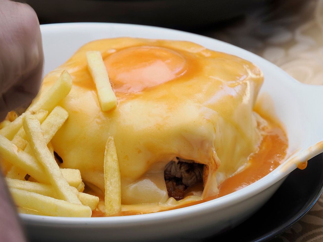 Francesinha typique de Porto, célèbre pour sa combinaison de saucisses, pain, viande et sauce spéciale