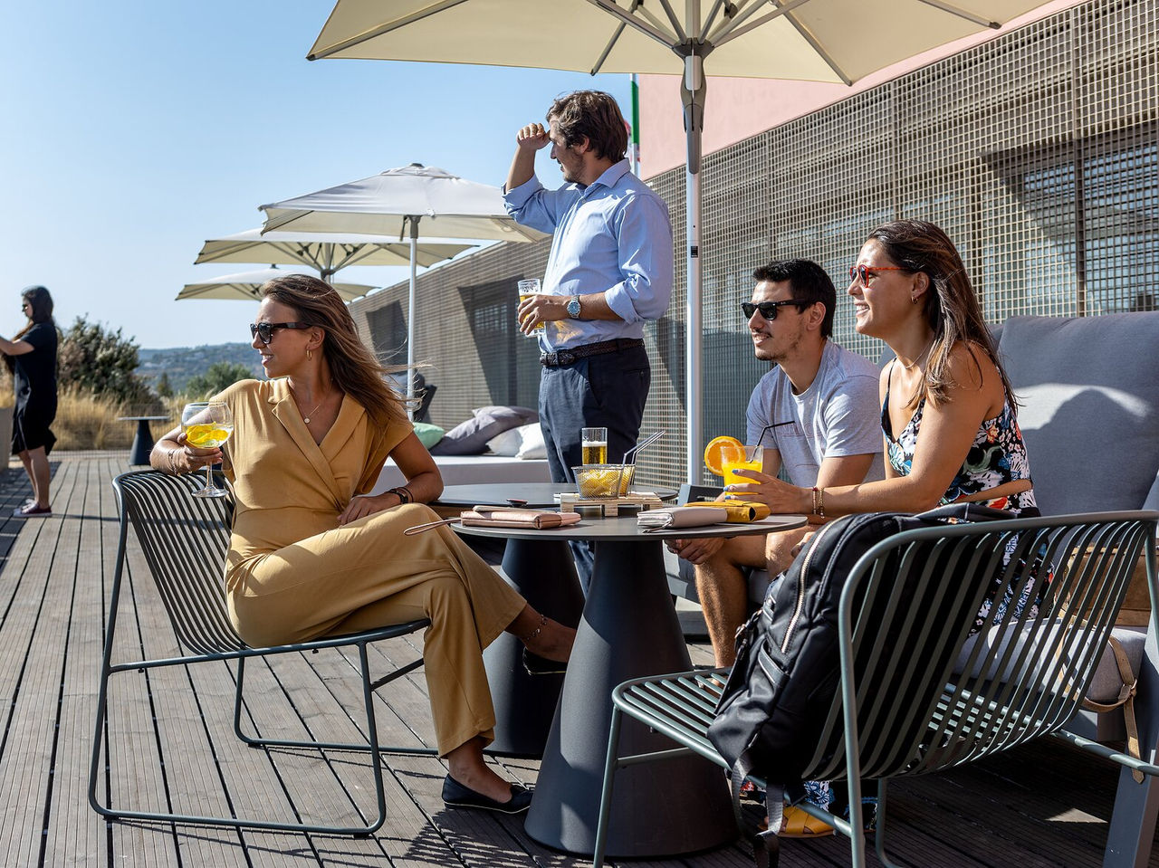 De bar Palácio, in het Historisch Hotel in Faro, heeft een terras waar een groep jongeren cocktails in de zon drinkt