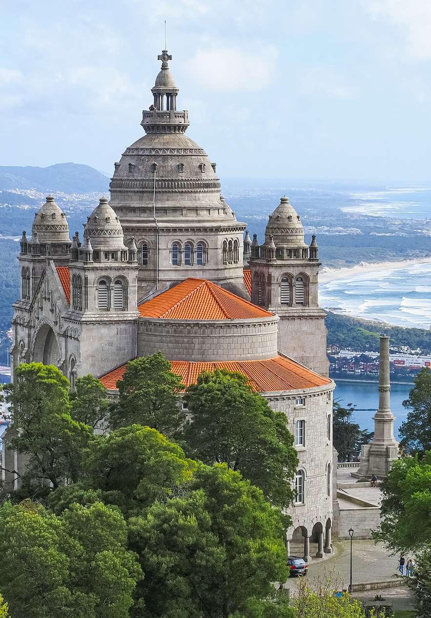 Basiliek van Santa Luzia met grote koepel en drie kleine koepels, bomen en zee op de achtergrond