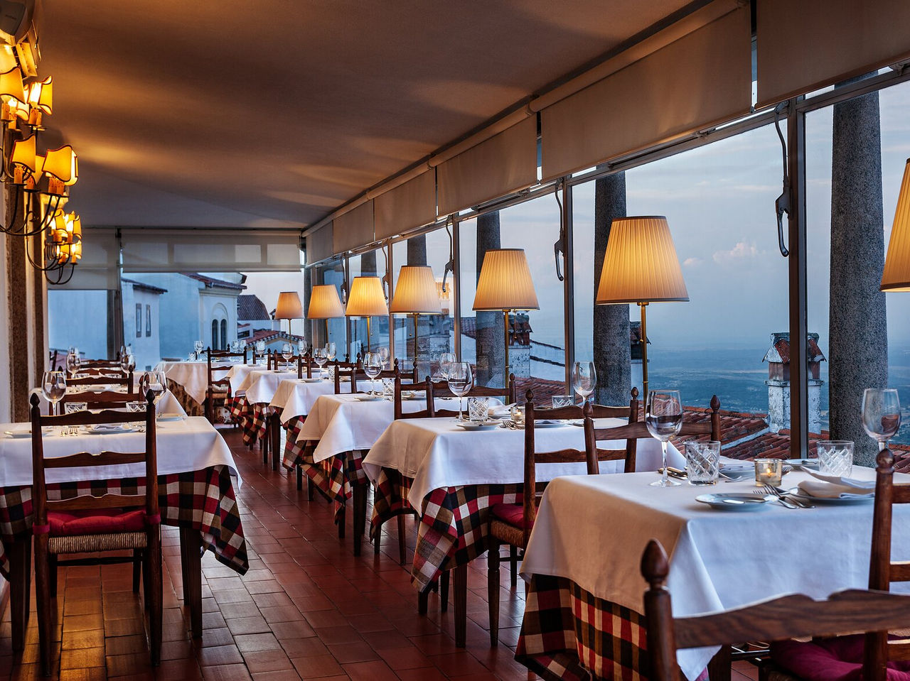 O restaurante Ninho D'Águias, do Hotel Histórico em Marvão, tem várias mesas e janelas grandes com vistas para a paisagem