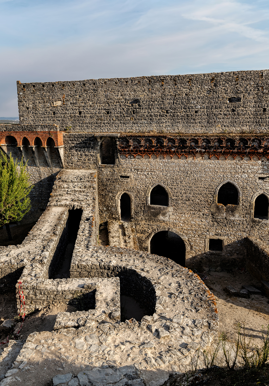 Castelo de Ourém, com várias janelas entre as muralhas e uma árvore do lado esquerdo