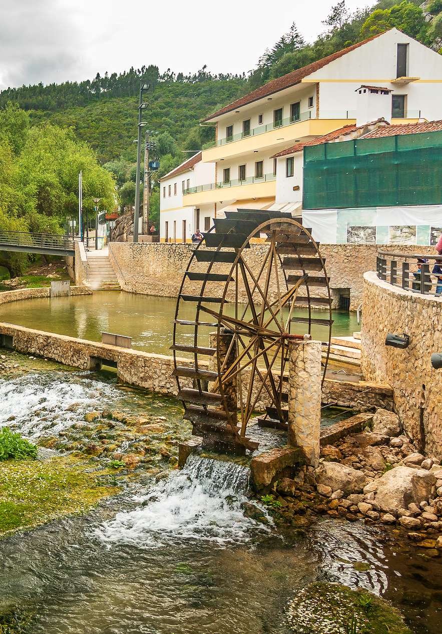 Roda de água num lago com socalcos com casas atrás, num parque natural perto de Ourém