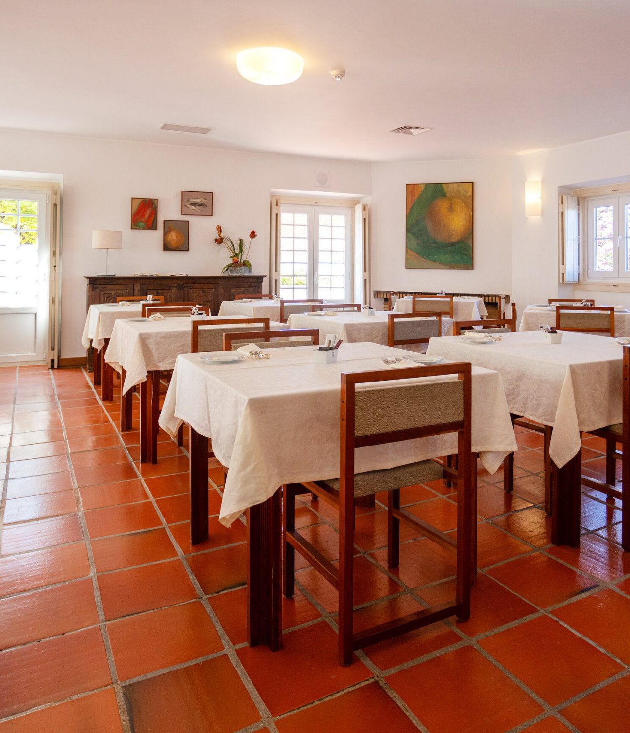 O restaurante do Hotel de Charme em Ourém, tem várias mesas preparadas para o pequeno-almoço e cadeiras