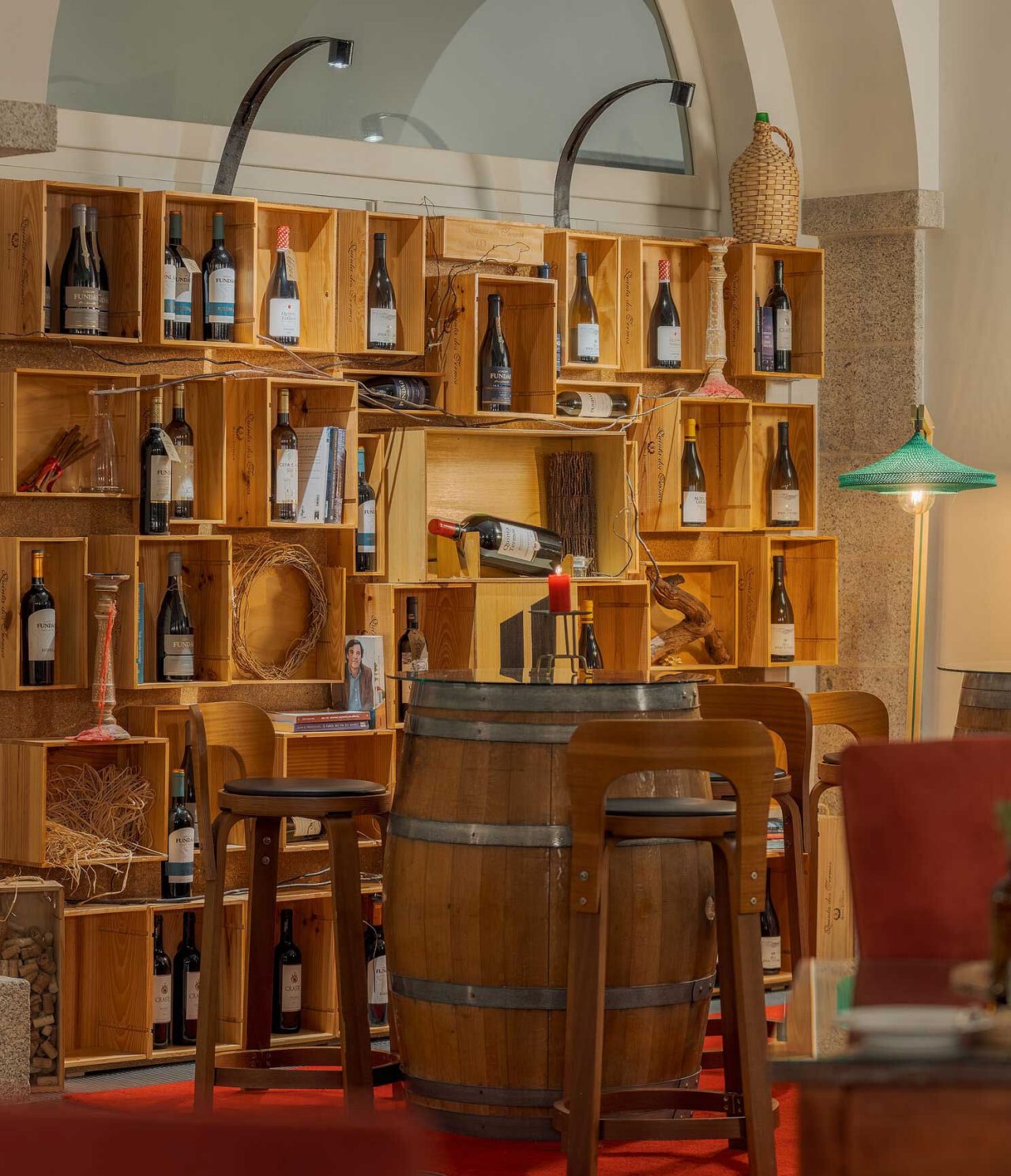 Bar da Pousada Serra da Estrela, com mesas em barris de madeira e prateleiras com garrafas de vinho