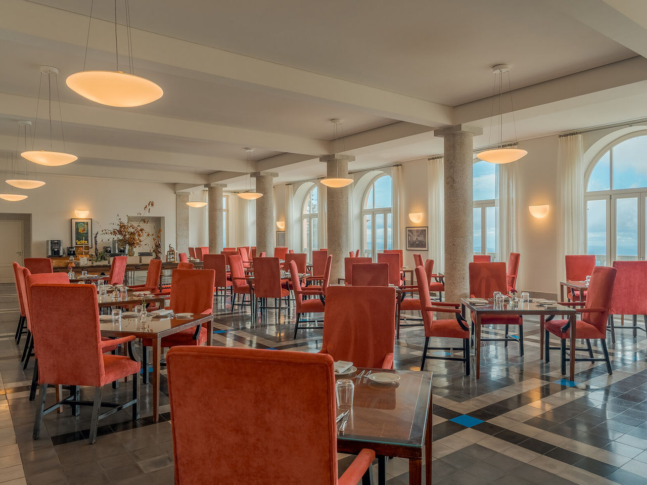 Restaurante da Pousada Serra da Estrela, sala ampla com janelas arqueadas e cadeiras vermelhas