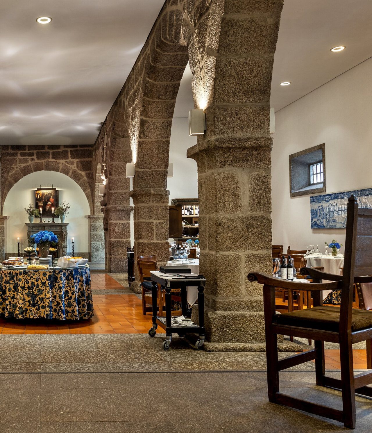 O restaurante D. Mafalda, do Hotel no Centro Histórico de Guimarães, tem arcos em pedra e uma mesa de buffet com comida