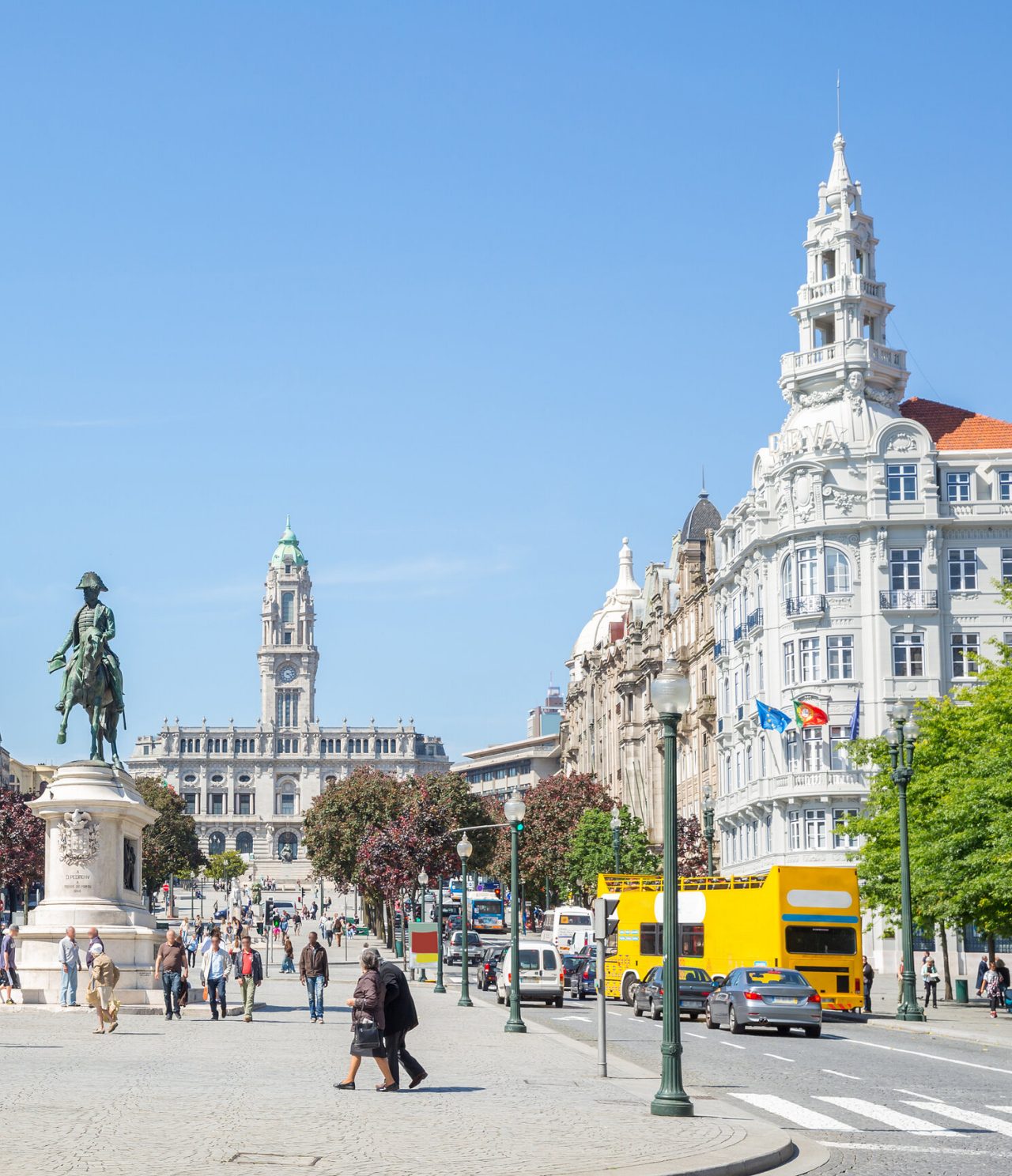 Agitação da Avenida dos Aliados na cidade do Porto, com pessoas a passear, carros e no trânsito e edifícios icónicos