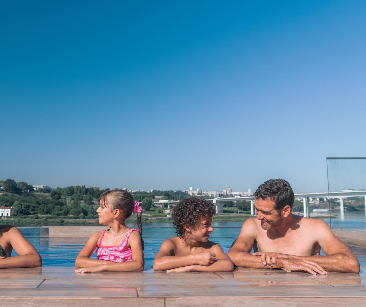 north-portugal hotel onde famílias relaxam numa piscina exterior com vista tranquila para o rio ao fundo