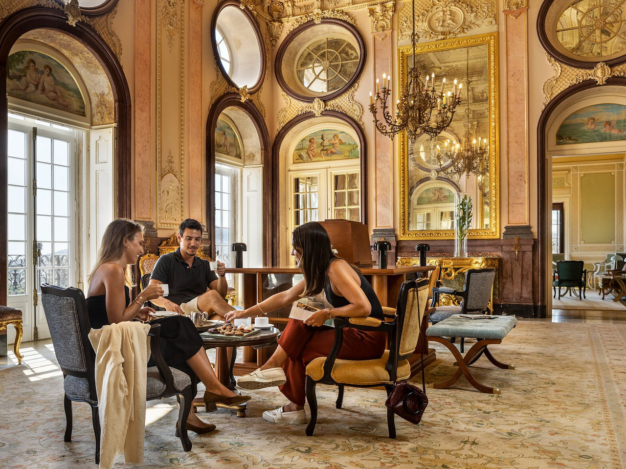Descubra Pousadas de Portugal, onde hóspedes convivem num salão clássico com espelhos dourados e lustres