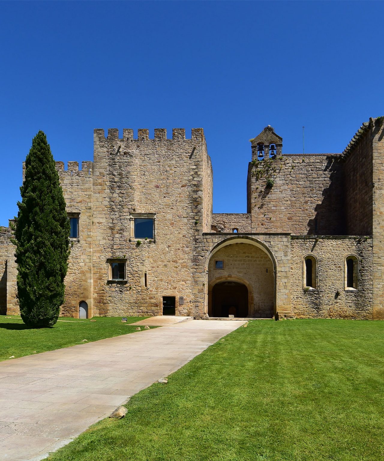 A marca Pousadas de Portugal apresentando castelo histórico em pedra com relvado e céu azul intenso