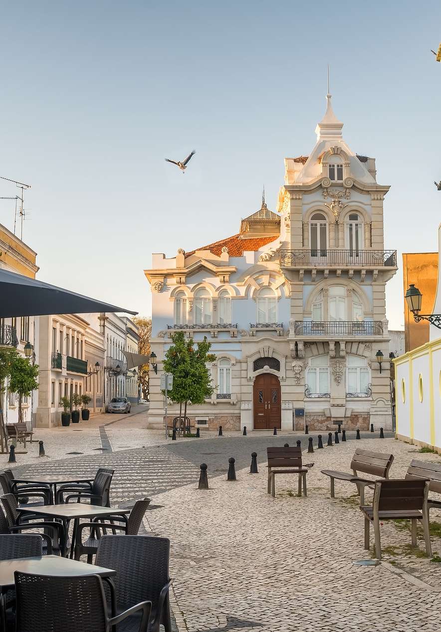 Square in Faro surrounded by Belle Époque architectural buildings and a café with an outdoor terrace with tables