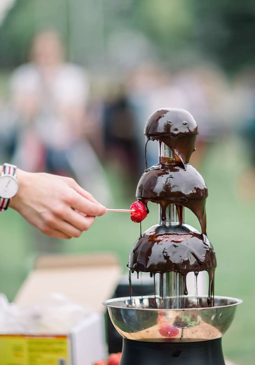 Strawberry being dipped in chocolate fondue at the Óbidos Chocolate Festival