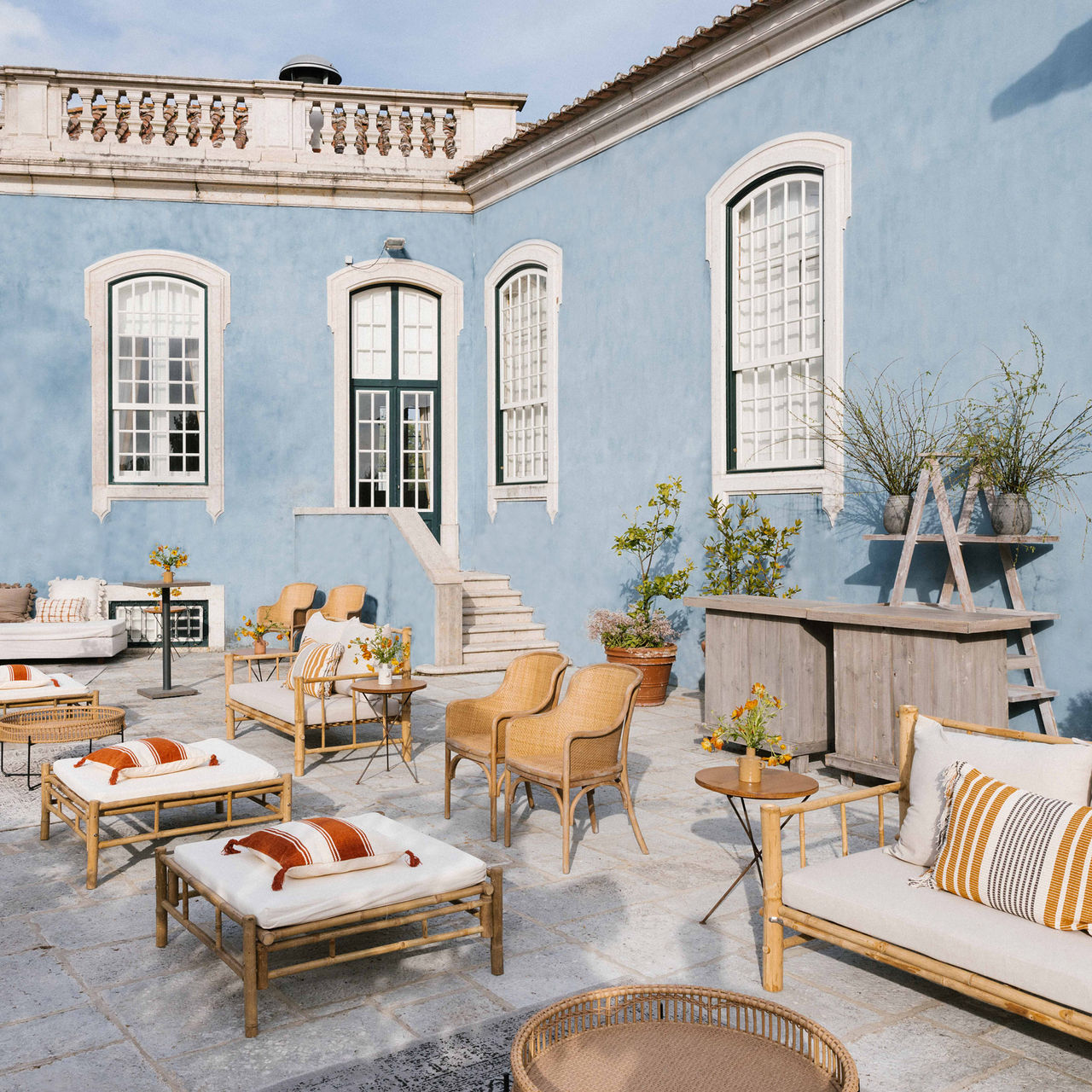Outdoor patio of Pousada de Queluz, featuring chairs and sofas with tables for guests to relax