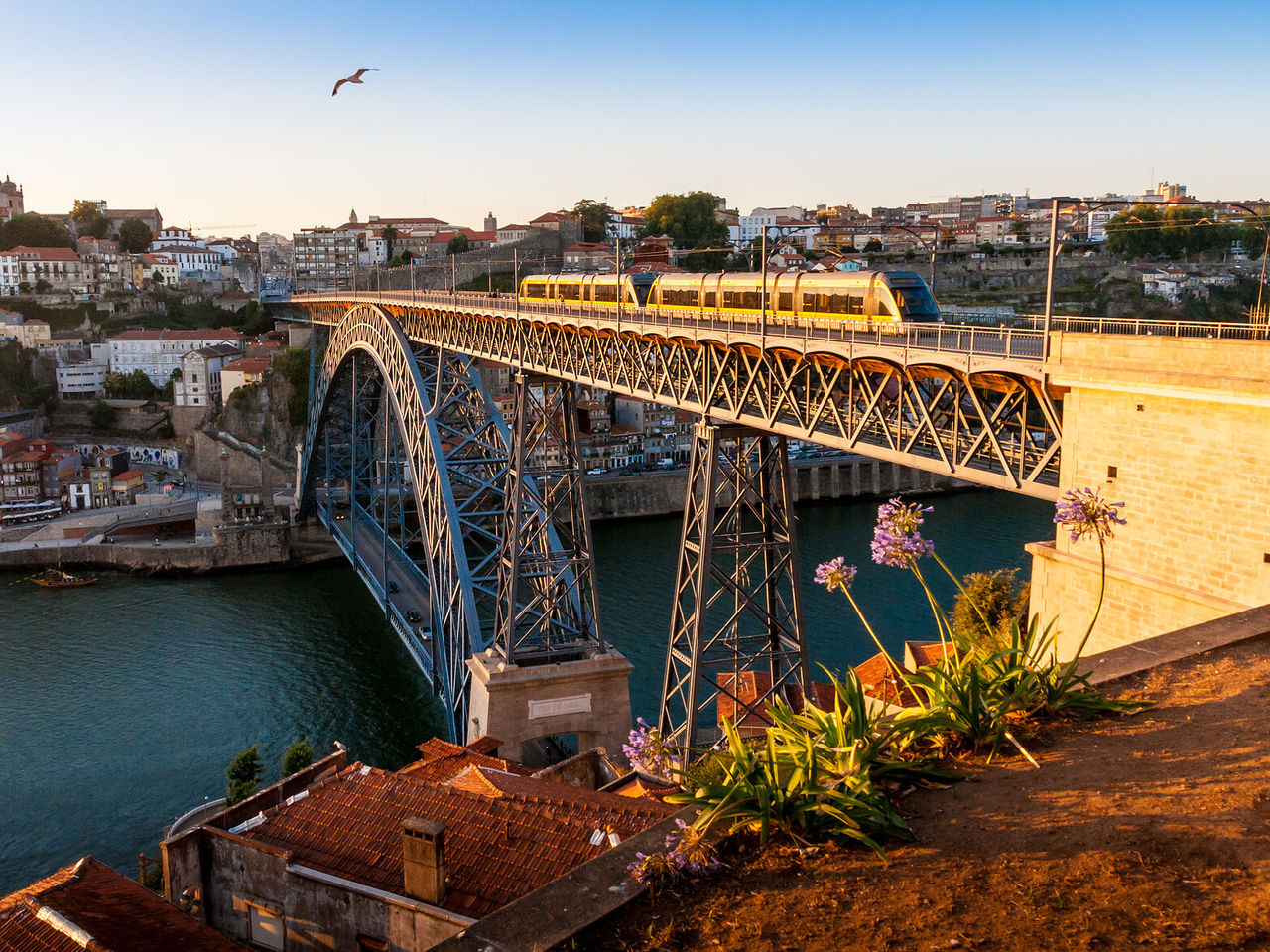 Explore Hotels in Porto featuring a sunset view of Dom Luís I Bridge and train crossing the Douro River