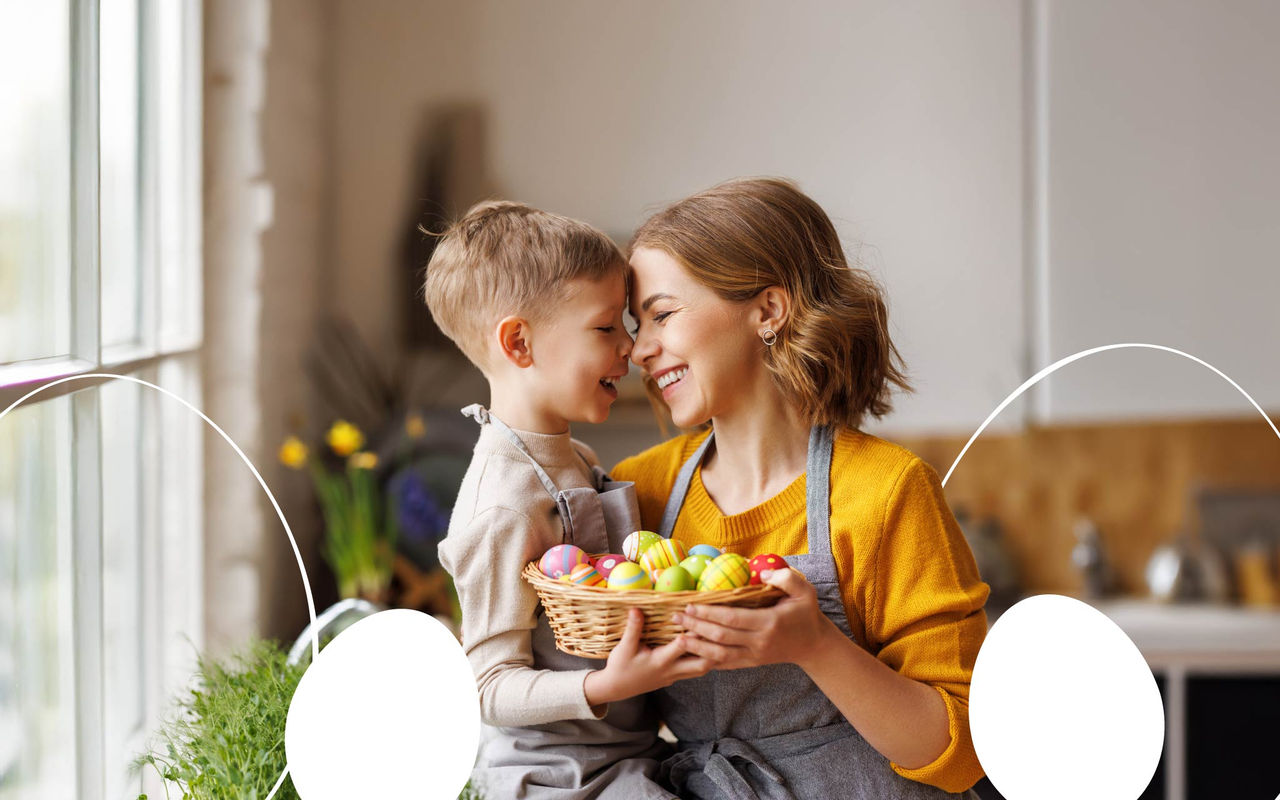 Mother and son in a tender embrace in the kitchen with a box of Easter eggs.
