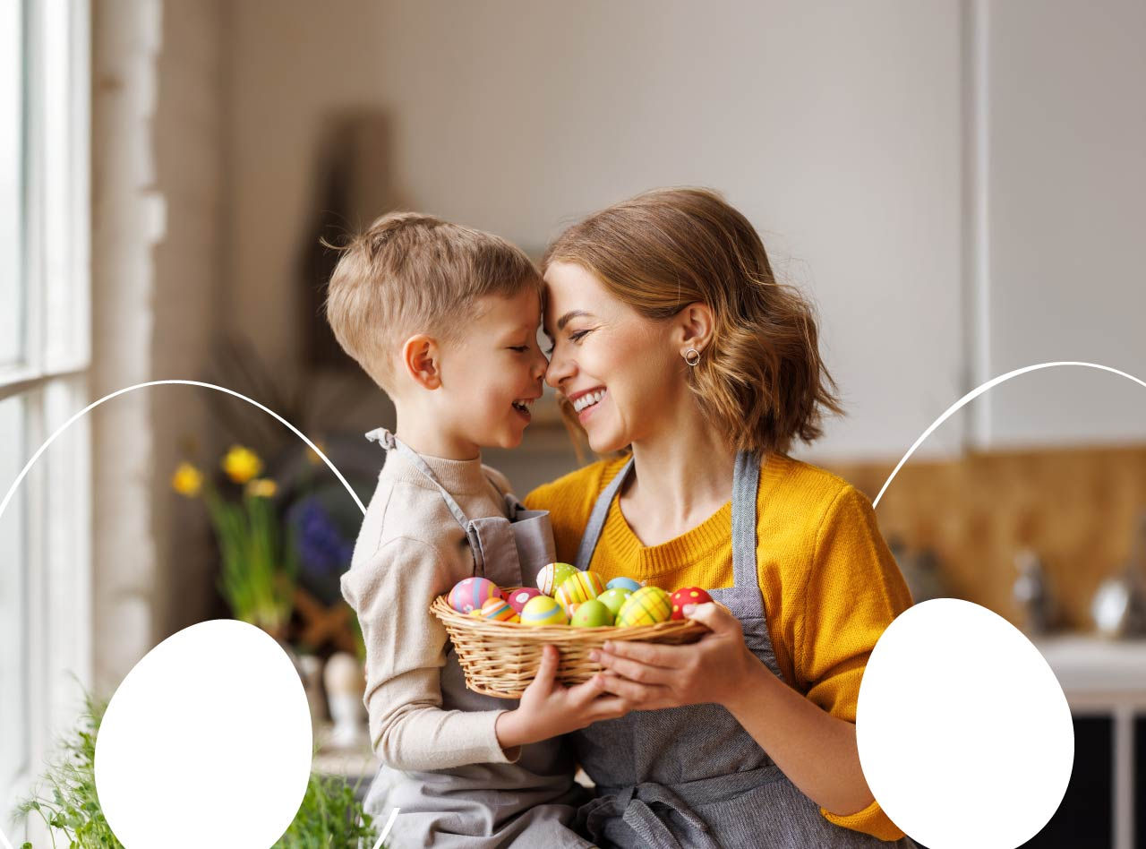 Mother and son in a tender embrace in the kitchen with a box of Easter eggs.